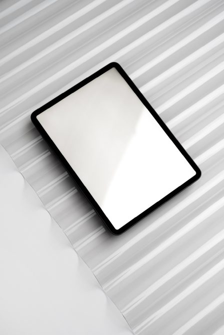 Minimalist tablet mockup with blank screen on striped surface, ideal for modern design presentations and digital portfolio showcases.